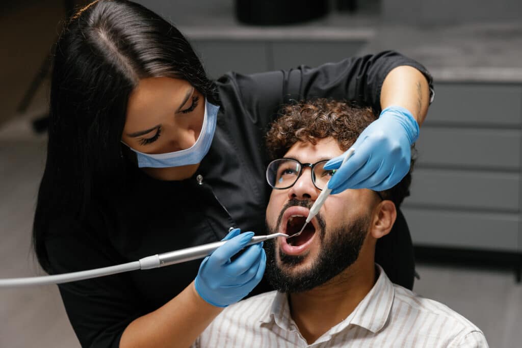 Dentist performing a dental cleaning on a patient in the office