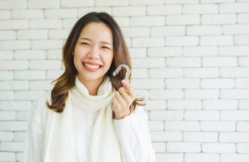 Dental patient holding their clear aligners