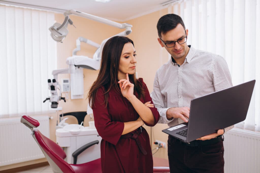 Dentist showing patient the pricing of dentla exams